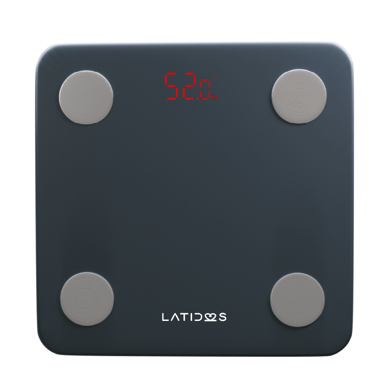 Balanza con monitor de grasa y bluetooth Latidos, vista anterior, de color gris oscuro, forma cuadrada con bordes redondeados. Con pantalla LED en la parte superior central encendida “52.0 kg” en color rojo. Cuatro sensores circulares grises ubicados en c. Haga clic para ampliar la imagen