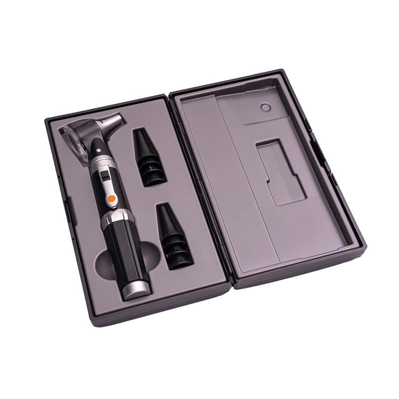 Otoscopio gmd, de color negro con detalles plateados, en un estuche negro abierto. El interior del estuche con un reborde gris con la forma del instrumento para ubicarlo. El otoscopio con botón negro y un detalle en color naranja. A su derecha se observan. Haga clic para ampliar la imagen