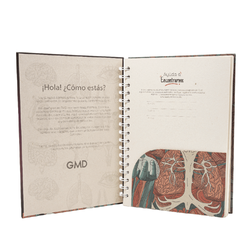Cuaderno argollado gmd anatomía carmesí, abierto; lado izquierdo con texto de introducción sobre fondo beige con ilustraciones anatómicas, y lado derecho con espacio para datos personales y en la parte inferir imagen de los riñones, con argollas blancas e. Haga clic para ampliar la imagen