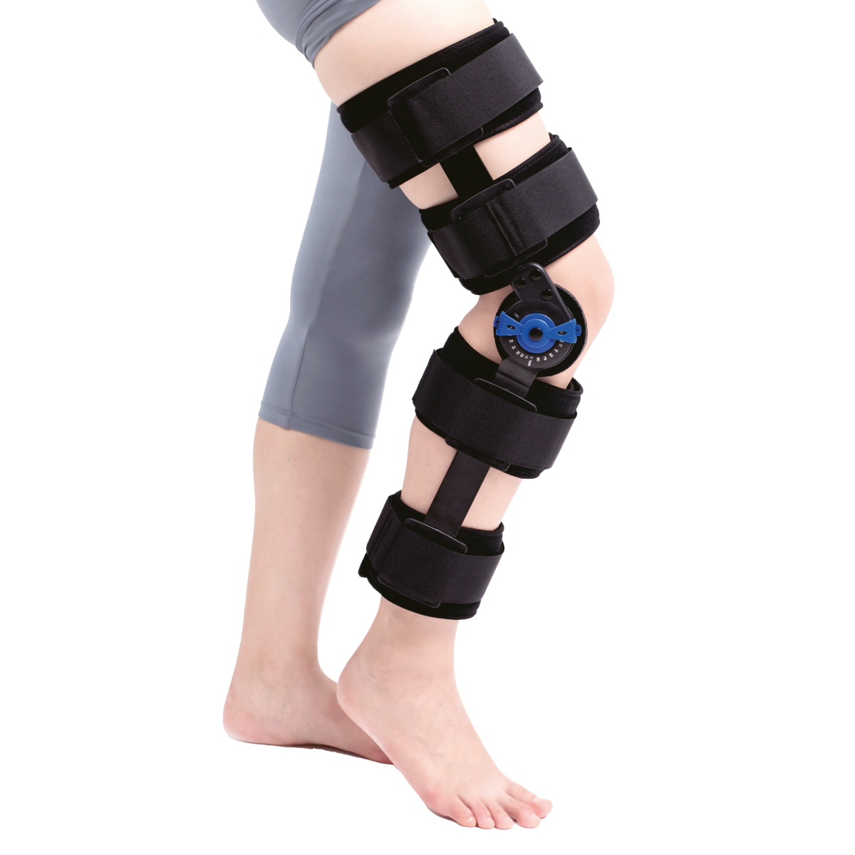 Brace articulado de rodilla GMD, talla M, de color negro. Cuenta con varias correas ajustables con velcro que rodean el muslo y la pantorrilla. En la zona lateral de la rodilla se observa un mecanismo de bisagra con regulador de ángulo en color azul, con 