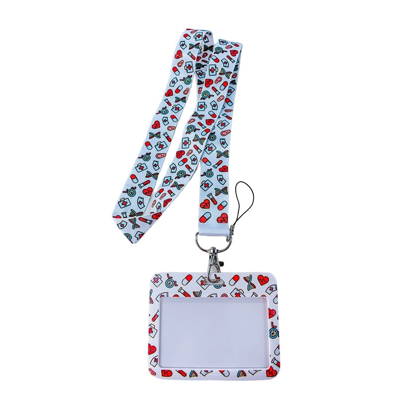 Porta carnet con lanyard modelo corazones y pildoras, vista frontal, con borde rectangular de color blanco con ilustraciones de corazones y pildoras; en el centro área transparente para el carnet y en la parte superior gancho metálico con correa blanca co. Haga clic para ampliar la imagen