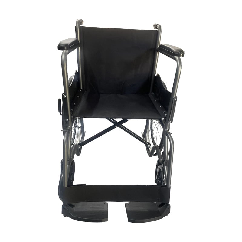 Silla de ruedas, vista frontal, con estructura metálica gris y negra, asiento y respaldo en tela negra, apoyabrazos acolchados y ruedas traseras grandes con radios metálicos. Con ruedas delanteras pequeñas giratorias, reposapiés negros y reposapiernas en . Haga clic para ampliar la imagen