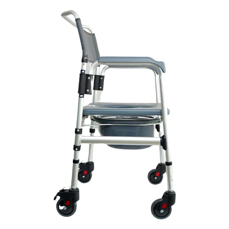 Cómodo sanitario plegable con ruedas en aluminio anodizado, vista lateral derecha, con estructura metálica de color plateado. Espaldar en malla de color gris y apoyabrazos acolchados de color gris. En el centro cuenta con asiento de color gris con apertur. Haga clic para ampliar la imagen
