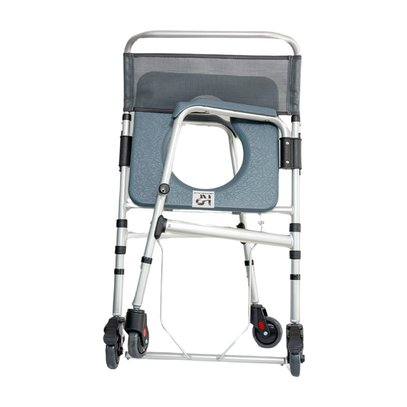 Cómodo sanitario plegable con ruedas en aluminio anodizado,  vista lateral, doblado. Estructura metálica de color plateado con detalles en color negro. Espaldar en malla gris, en posición comprimida contra el asiento de color gris. Las cuatro patas cuenta. Haga clic para ampliar la imagen