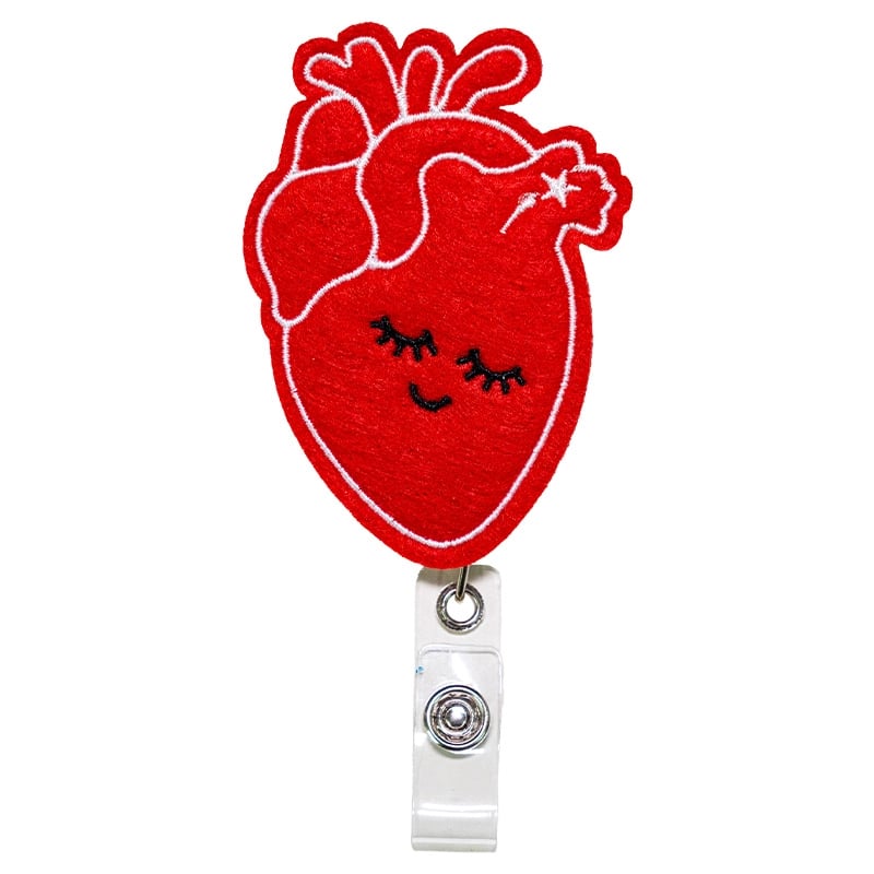 Porta carnet de corazón feliz, de color rojo, con borde blanco cosido. Tipo yoyo retráctil. Se conecta mediante un gancho metálico triangular unido a un aro metálico. Desde este aro se extiende un adaptador de color blanco con broche metálico para sujetar. Haga clic para ampliar la imagen