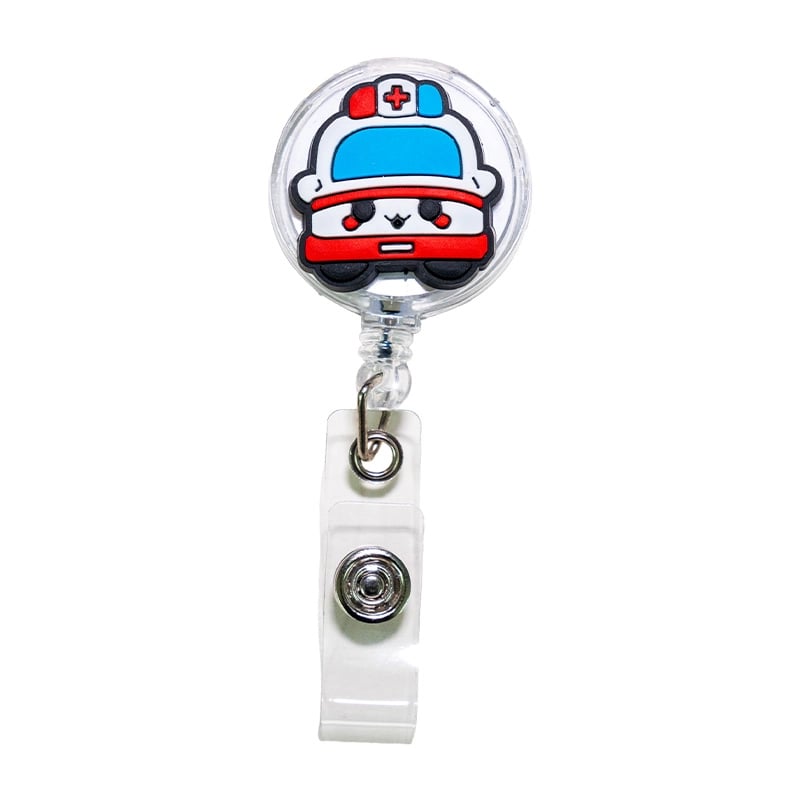 Porta carnet en forma de ambulancia, tipo yoyo retráctil. En la parte superior presenta una base circular con diseño de ambulancia en colores blanco y rojo. Se conecta mediante un gancho metálico triangular unido a un aro metálico. Desde este aro se extie. Haga clic para ampliar la imagen