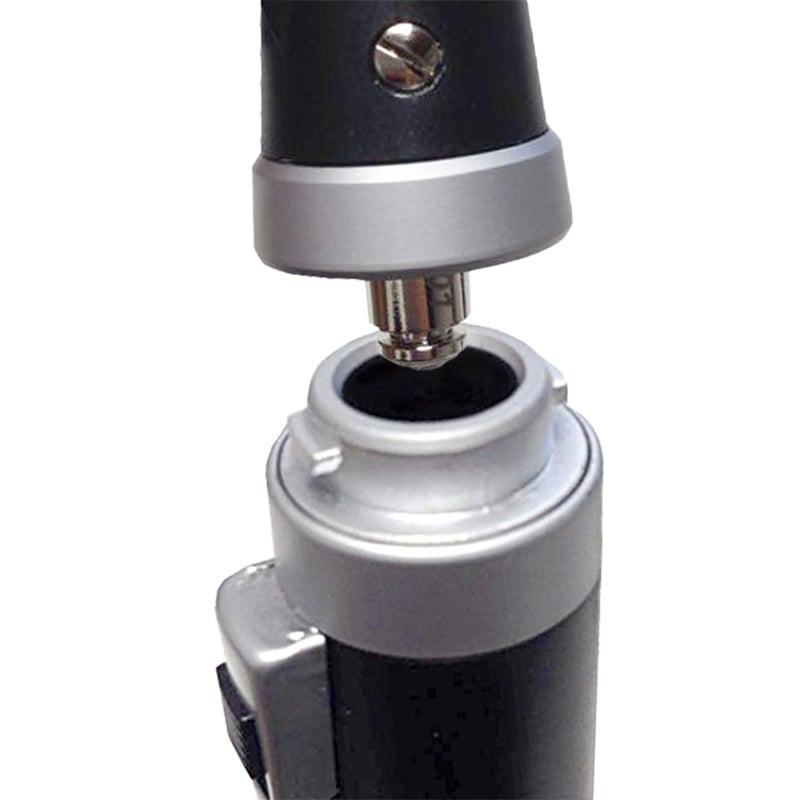 Otoscopio gmd, de color negro. Sistema de ensamble entre el cabezal y el mango del instrumento, mostrando la unión mediante un conector metálico plateado tipo rosca o encaje, el anillo de acople plateado y el pin central metálico de conexión.. Haga clic para ampliar la imagen