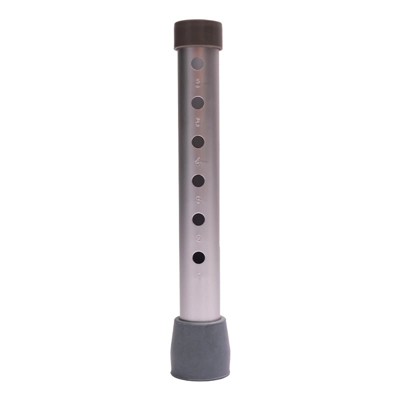 Pata para comodo sanitario, de forma vertical, metálica de color plateado. En el extremo inferior cuenta con goma antideslizante de color gris, y en el extremo superior en color negro. En la zona central graduadores con pqueños orificios circulares del 1 