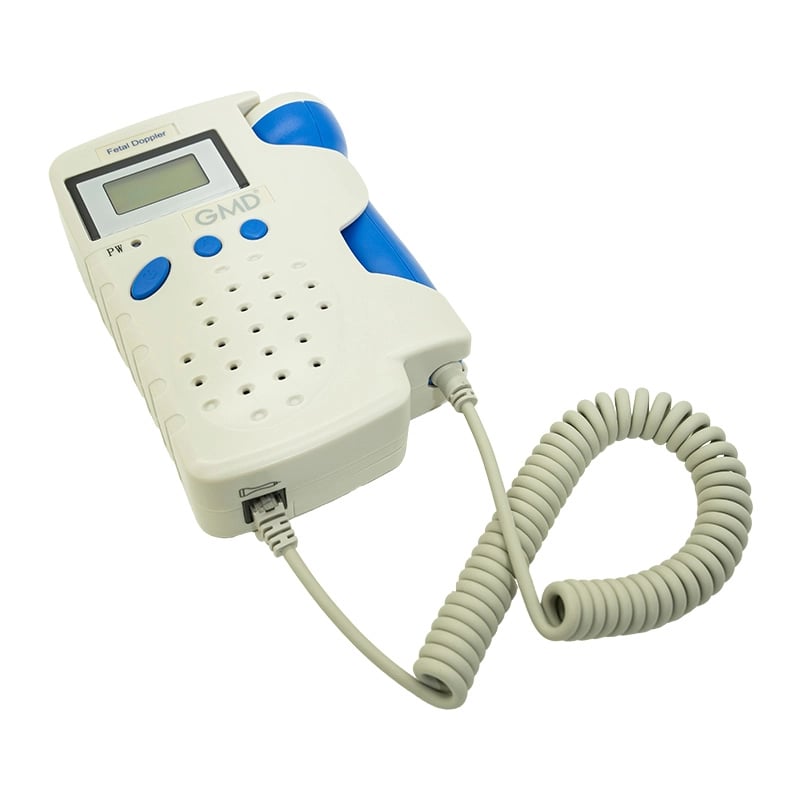 Doppler fetal GMD, de color blanco con detalles en azul. Cuenta con pantalla LCD en la parte superior apagada, botones de control en color azul debajo de la pantalla y rejilla de altavoz bajo los botones. En el lateral derecho se observa el transductor co. Haga clic para ampliar la imagen