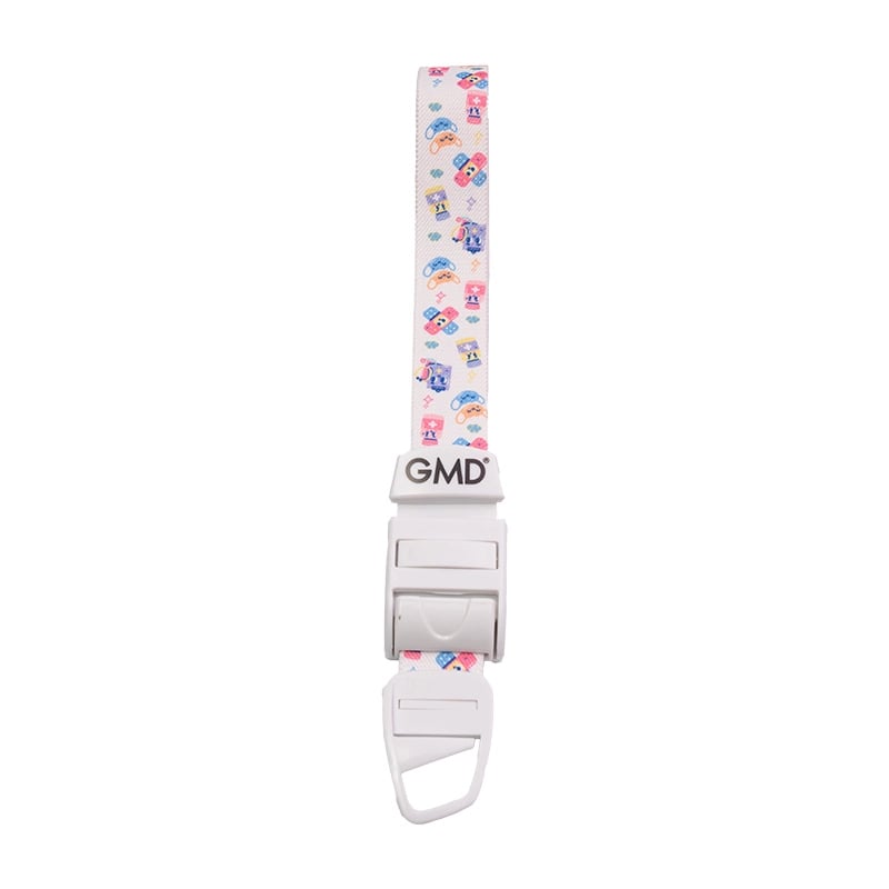 Torniquete GMD motivo Caritas medicas, fabricado en material elástico tipo látex y poliéster; cuenta con un sistema de broche de seguridad y liberación rápida de color blanco, elaborado en material plástico.. Haga clic para ampliar la imagen