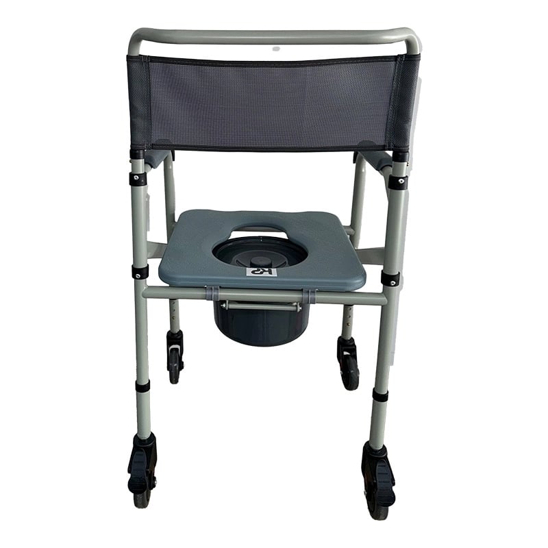 Cómodo sanitario plegable con ruedas acero pintado, vista posterior, estructura metálica plateada y espaldar rectangular en malla gris. Apoyabrazos acolchados grises a ambos lados. En el centro, asiento gris con apertura ovalada tipo inodoro y recipientec. Haga clic para ampliar la imagen